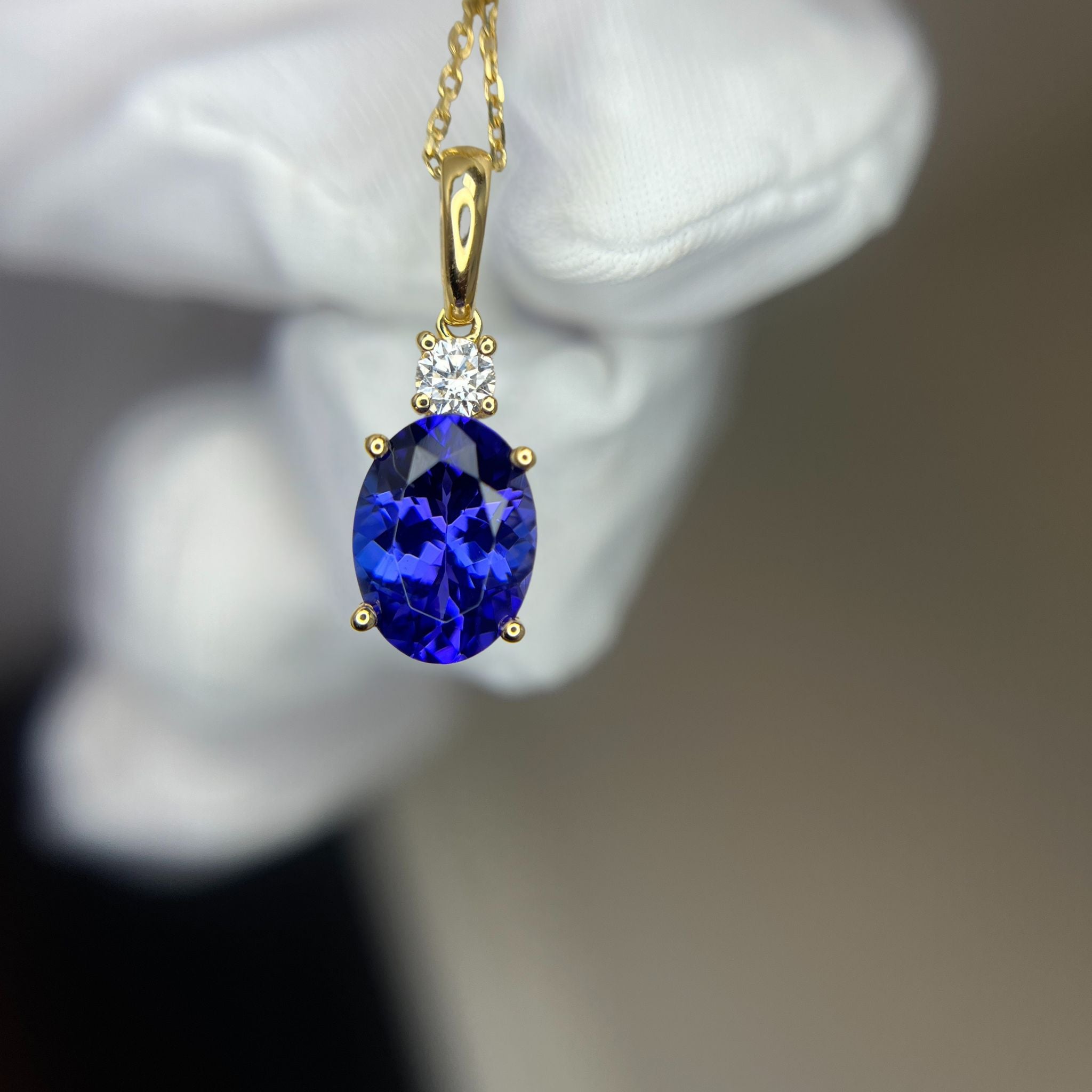 Gold pendant with a blue tanzanite gemstone and diamond.  
