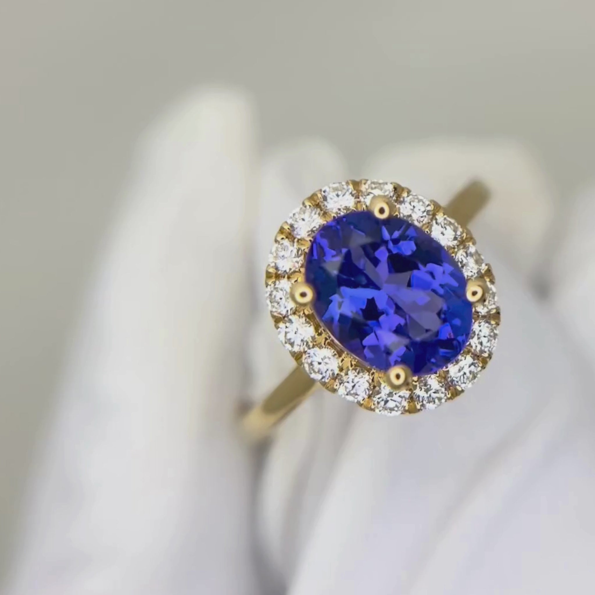 Tanzanite and diamond halo ring in yellow gold 